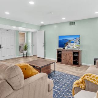 A cozy and modern living room featuring comfortable seating, a stylish coffee table, and a large television.