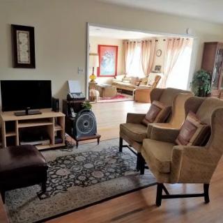 A cozy living room with comfortable seating, a television, and ample natural light.
