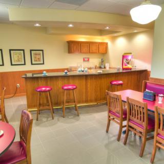 A cozy kitchen and bar area with stools and tables, ideal for casual dining.