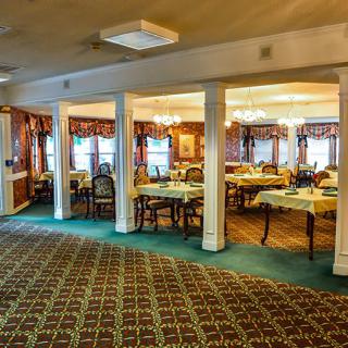 A cozy dining room with elegantly set tables and classic decor.