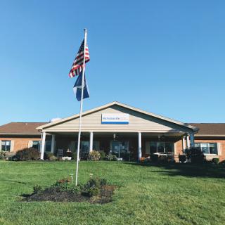 A community building with flags standing proudly against a clear blue sky.