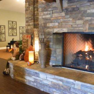 A cozy living room with a stone fireplace and warm lighting creates a welcoming atmosphere.