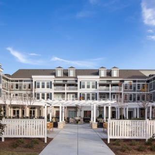A modern residential building with a bright facade and clear blue sky.