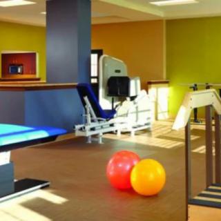 A well-equipped fitness area with exercise machines and therapy balls.