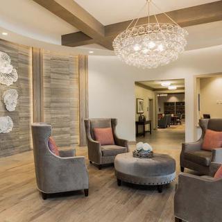 A modern lobby with elegant armchairs and a chandelier.