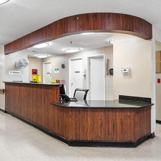 A hospital reception area with a wooden desk and computer equipment.