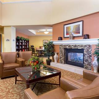 A cozy lobby with comfortable seating, a fireplace, and elegant decor.