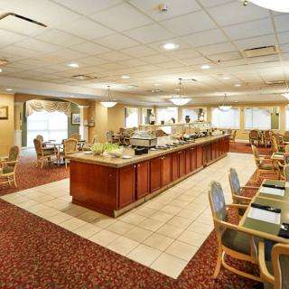 An elegantly designed dining area with a central buffet setup, featuring comfortable seating and ambient lighting.