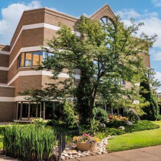 A modern office building surrounded by well-maintained gardens and landscaping.