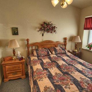 A cozy bedroom with a wooden bed, floral bedspread, and matching nightstands.