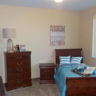 A cozy bedroom with wooden furniture and teal accents.