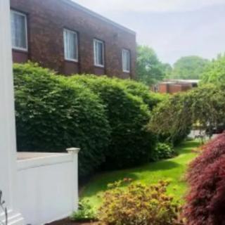 A brick building with well-maintained hedges and landscaping.