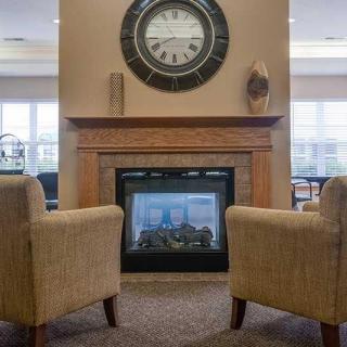 A cozy living room with a fireplace and two comfortable chairs.