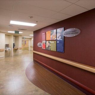 A hospital hallway with informational signs on the wall.