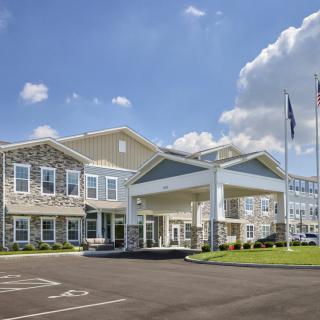 Exterior view of a large hotel building under a blue sky with scattered clouds.