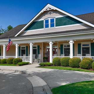 A beautiful single-story house with white columns and a manicured garden.