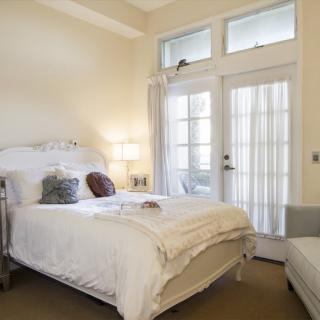 A cozy bedroom with a comfortable bed and ample natural light.