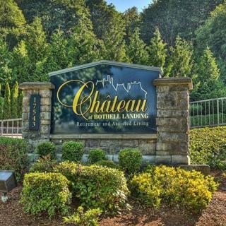 Entrance sign for Chateau Estates, surrounded by lush greenery and stone pillars.