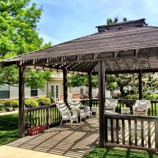 A charming gazebo with outdoor seating on a sunny day.
