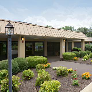 A well-maintained building surrounded by lush gardens and vibrant flowers.