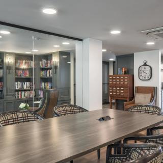 A modern conference room with bookshelves and a large meeting table.