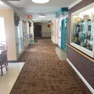 A carpeted hallway with seating areas and decor along the walls.