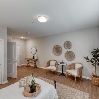 A modern and minimalist bedroom with cozy seating and tasteful decor.