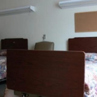 A hospital room with two beds separated by a privacy curtain.