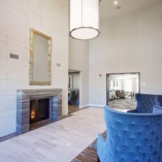 A modern living room featuring a cozy fireplace and stylish blue seating.