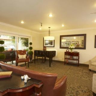 A cozy living room with elegant furniture, including sofas and a wooden table, enhanced by warm lighting and decorative elements.