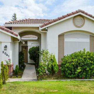 A suburban house with a landscaped front yard and pathway.