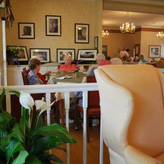 Seniors relaxing in a cozy retirement home interior with photographs on the walls.