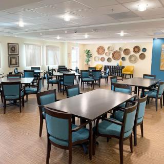 A modern dining area featuring several tables and chairs, with art adorning the walls.