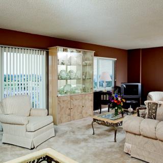 A cozy living room featuring comfortable seating, a cabinet display, and a television.