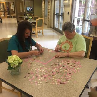 Two individuals engaged in assembling a puzzle together, enjoying a moment of creativity.