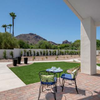 A serene patio with outdoor seating and a view of the mountains on a sunny day.