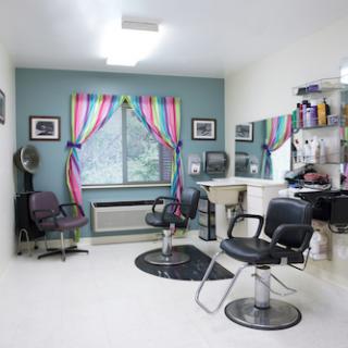 A cozy and colorful hair salon interior with stylish chairs and vibrant curtains.