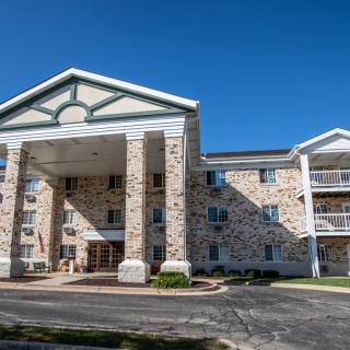 A multi-story residential building with a prominent entrance and stone facade.