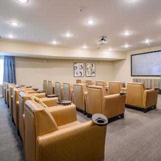 A modern conference room designed for comfort and productivity, featuring plush seating and a large projector screen.