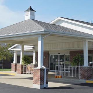 A building entrance with a canopy and brick pillars on a clear day.