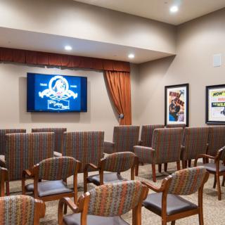 A modern waiting area featuring arranged chairs and a mounted television.