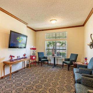 A cozy living room with comfortable seating, a wall-mounted television, and decorative elements.