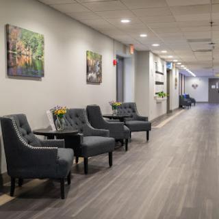 A well-lit and elegantly designed waiting area featuring comfortable seating and decorative art on the walls.