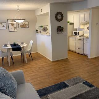 A cozy apartment with an open floor plan, featuring a living room, dining area, and kitchen with modern decor.