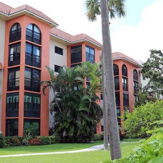 A tropical residential condominium with lush greenery and palm trees.