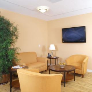 A cozy waiting room with comfortable seating and a television.