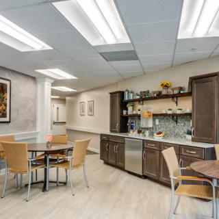 A modern break room with wooden furniture and contemporary lighting.