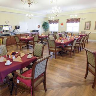 An elegantly decorated dining room with set tables and chandeliers.