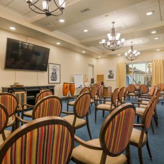 A well-arranged conference room with striped chairs and a large television screen.