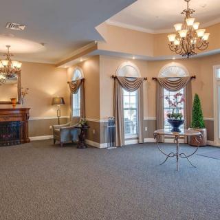 Elegant room with chandeliers, a fireplace, and large windows.